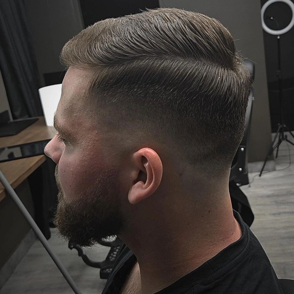 Przedziałek z przejściem skin fade i wyprofilowana broda